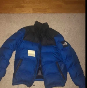 North face jacka vintage  - Blå jacka nuptse 1992 modell, i M (killmodell), har några små hål vid armen annars är den jätteskön att ha till vintern. Pris kan diskuteras😊