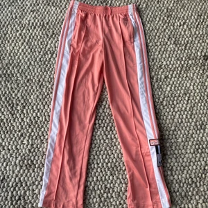 Adidas utsvängda byxor, Strl S - Ett par oerhört coola, fina och unika Adidas byxor med 90-tals vibe. Säljes då dessa inte kommer till användning och är enbart använda 1 gång. Strl S. Köparen står för frakt. 