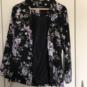 Blazer - En riktigt söt blommig blazer i runt material från Gina.
