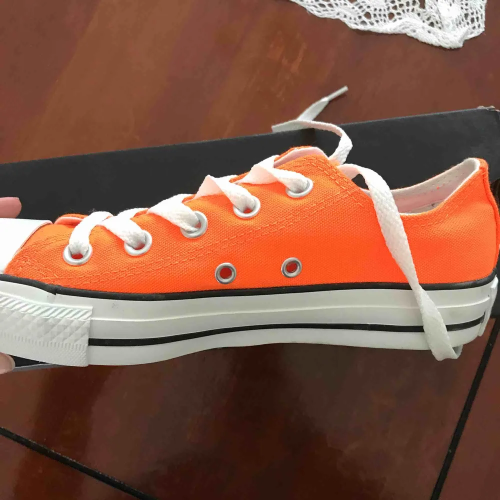 Ett par orangea Converse i kort modell. Skorna är i nyskick, aldrig använts och är i storlek 36,5 eller 6. Köpta i USA och kommer självklart med ordinarie skokartong. Nypris på dessa är cirka 500kr. Skor.