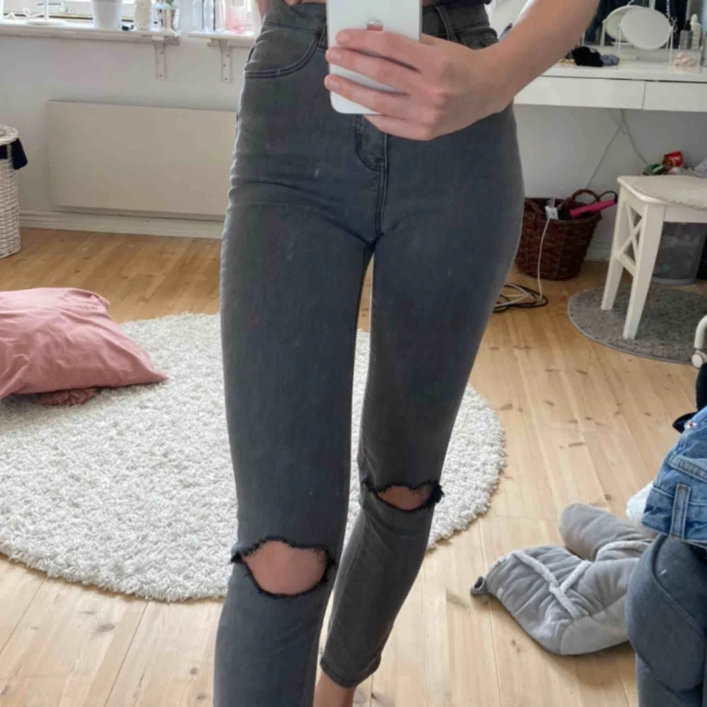 Högmidjade grå jeans i storlek 34/XS från nakd med hål på knäna! knappt använda så i super fint skick! Du betalar frakten🥰. Jeans & Byxor.