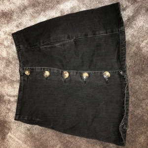 Svart kjol - En snygg svart jeanskjol men knappar framtill. Aldrig använd då den var lite stor för mig så helt nytt skick. Storlek 34. Betalas via swish och priset är inklusive frakt!😊
