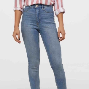  - Ett par jeans i stretchigt material. Jeansen har smala ben och fuskfickor fram samt bakfickor. Hög midja. Gylf med dragkedja och knapp.  Bild lånad från hm