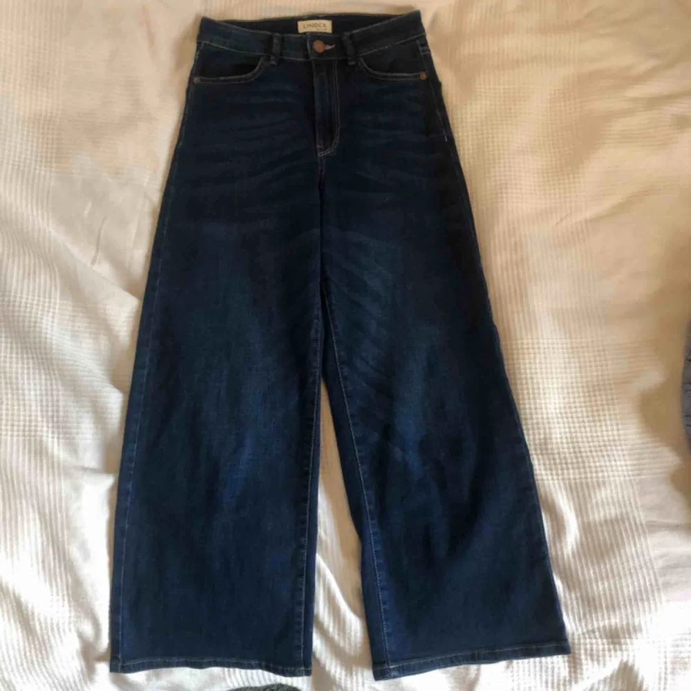 Ett par sparsamt använda mörkblåa högmidjade jeans från Lindex. Det är 34 men passar mig som har 36. Jag är 173 cm lång och de slutar en bit över anklarna så är lite korta för mig. Frakten står köparen för! Skriv så diskuterar vi🤗. Jeans & Byxor.