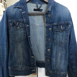 Jeansjacka - Jeansjacka, okänt märke. Lite mörkare blå med snygga knappar. Perfekt nu till vår! 