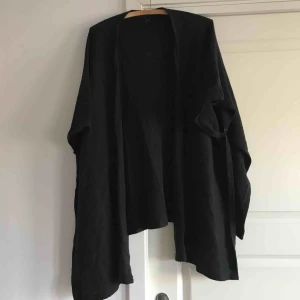  - Mysig stickad poncho med fina ärmar m knapp, se bild