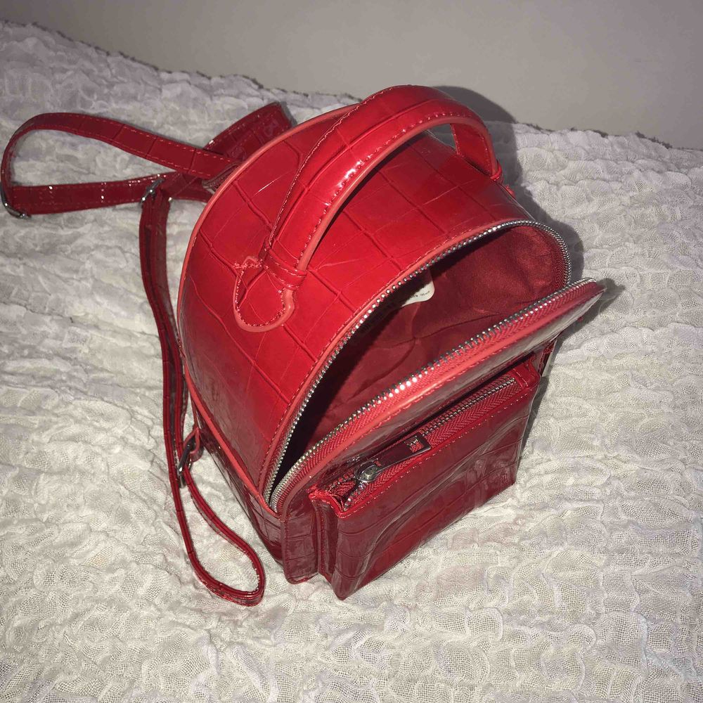 Röd lackryggsäck från Bershka Frakt ingår i priset. Väskor.