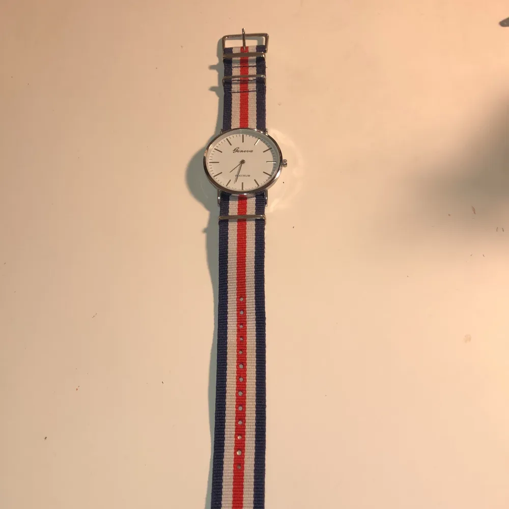 En otroligt fin geneva klocka som inte har kommit till användning. Marinblåa, vita och röda ränder och ett silverur. Går även att justera i längden. Batteri ingår ej! ☺️🌸. Accessoarer.