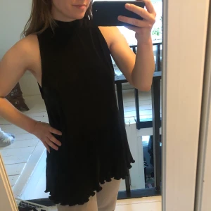 Lång blus storlek XS - Jättesöt blus från Aéryne. Lång modell. Ribbat, tjockt material. Cutout i ryggen och 2 band som knyts i nacken. Hög krage, vågig i nederkanten. Visar lite sideboob ✨ känns väldigt lyxig! Knappt använd! Obs! Katt finns i hemmet 🥰