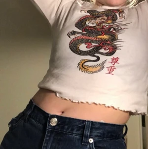 Vit tröja med draktryck - Säljer denna vita långärmad från new tornet. Nästan aldrig använd så i fint skick! Supersöt och ger lite 90 tals vibbar!