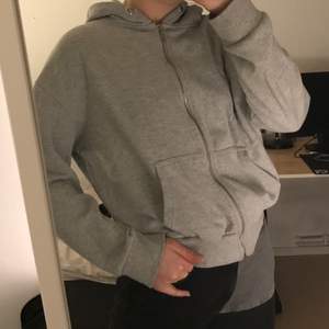 Grå hoodie med dragkedja som sitter snyggt oversize men inte för lång