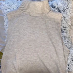 En stickad tröja  - En stickad beige tröja utan ärmar och även med krage. Köpt från zara för en månad sen. Man kan ha vad som helst under, passar till allt möjligt. Den är i storlek M. Inte stor och inte liten men lite lös, den slutar vid mitten av rumpan på mig. Köpt för 300