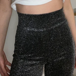 BikBok glitterbyxor - Perfekta glitterbyxorna till nyår (eller annat skoj) Dom är stretchiga, känns knappt på kroppen och sitter oerhört skönt! Använda ett fåtal gånger, några trådar som lossnat men inget som syns på håll! Raka ner till i passform och höga i midjan 