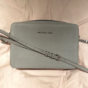 Michael Kors crossbody bag  - Michael Kors vintage crossbody väska. Endast använd enstaka gånger. Superfint skick. För fler bilder, skriv!  • 100% Saffiano Leather • Silver-toned grey • 22.86 x 10.16 x 2.54 cm • Justerbar rem • Tre slitsfickor • Pris är förhandlingsbart 