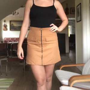 Kamelfärgad kjol. - Kamelfärgad kjol med dragkedja fram, köpt på primark. Väldigt snygg passform och material. Storlek 40, jag är 174 cm och tycker inte den känns för kort.