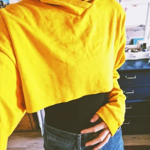 Gul cropped hoodie - Gul cropped hoodie i oversized modell, lång i ärmarna. Använd men i gott skick. Möts upp i Malmö eller fraktas, köparen står för fraktkostnad. 