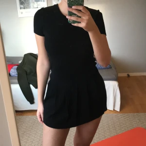 Svart gantklänning - Svart klänning i superskönt tungt tyg! Lite nopprig som man kan se på bild 3. Nedre delen av klänning liknar lite en tenniskjol så den ser lite sportig ut:) Gant är också skrivet diskret i svart glitter. Den är i barnstorlek XXL så därför har jag skrivit XS. Säljer så jag tycker den är för kort för mig som är 170 cm. Skulle därför rekommenderar för någon kortare än jag.