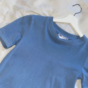 Zara blå T-shirt  - Säljer denna super fina T-shirt ifrån Zara. Köpt för en månad sedan men har inte kommit till användning. Använd en gång och är i nyskick!                                                             Hör av er vid frågor eller intresse💙.                                   70kr + frakt