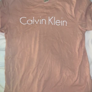 Rosa Calvin Klein t-Shirt  - Säljer min rosa Calvin Klein t-Shirt på gund av ingen användning. Det är en xs men sitter som S. Ny pris 500 bra skick och inga hål eller fläckar som inte går bort. står ej för frakt +44 kr BUDA I DM! 
