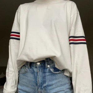  Vit sweatshirt med detaljer. - En vanlig vit sweatshirt fast med detaljer. Enkel och snygg design som passar till allt.Tröjan är ifrån Brandy Melville och den är i storleken onesize.Säljes för 50 kr. Köparen står för frakten.