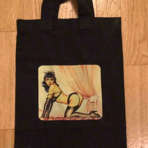  - En tygväska med en pinuppa på