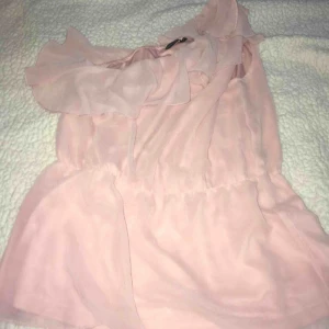  - Topp med en axel. Rosa färg i storlek 38. Jättefin till lite festligare tillfällen eller även till vardags. Oanvänd då den är för stor för mig!  • Köparen står för frakt!