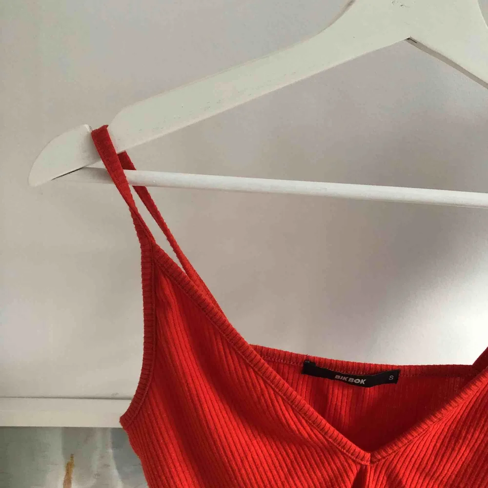 Rött linne från BikBok, ganska urringat men perfekt när det blir varmare väder! Sällan använt i gott skick! Eventuell frakt står köparen för ✨🌿🌼💕. Toppar.