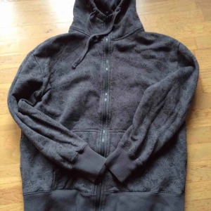  - Sparsamt använd grå hoodie med massa print, bla döskallar. Storlek M. Se bild 2 o 3 för närbilder på print, färgen stämmer med bild 1. Priset är inkl vanlig frakt.