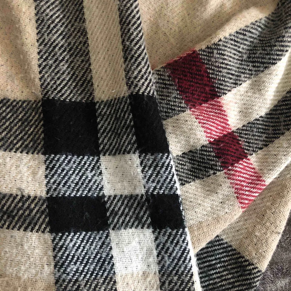 En stor scarf som är som en filt. Väldigt varm och har två mönster. Burberry märke utåt och grå inåt.. Accessoarer.