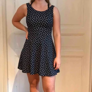  - Blå klänning med vita prickar. 