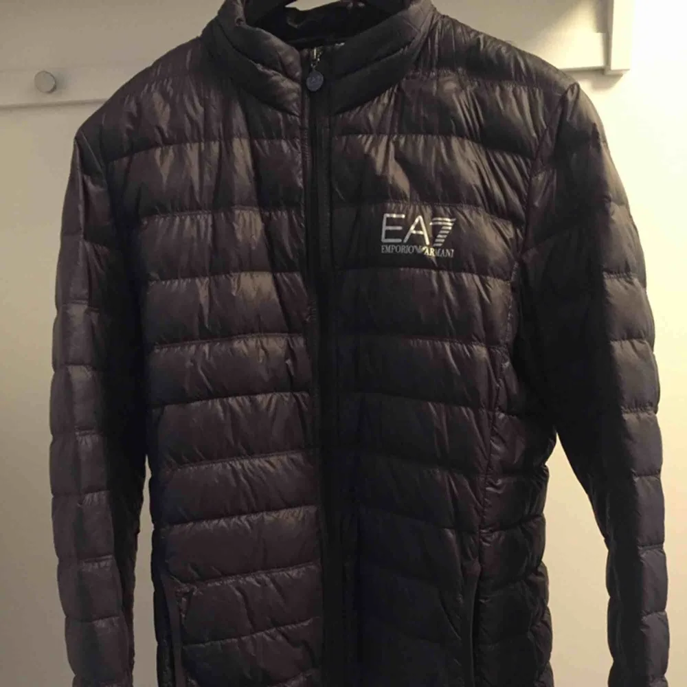  EA7 Emporio Armani dunjacka: Jackan är inköpt på Johnells 2018 för 1800kr, Jackan är i storlek XL men sitter som en L. Den är i väldigt fint skick och knappt använd. Färg: Anthracite gray . Jackor.