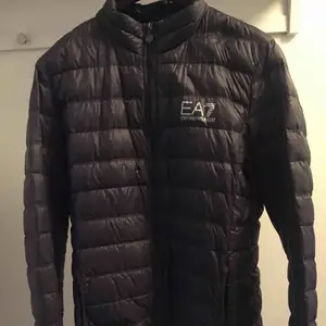  EA7 Emporio Armani dunjacka: Jackan är inköpt på Johnells 2018 för 1800kr, Jackan är i storlek XL men sitter som en L. Den är i väldigt fint skick och knappt använd. Färg: Anthracite gray 