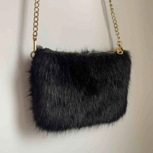  - Axelremsväska i fuskpäls från Don Donna. Längd: 20cm Bredd: 27cm. Kedjan är 42cm lång. 