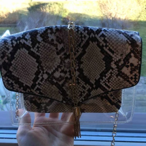  - Liten genomskinlig väska med ormskinn(fake) och guld detaljer. 