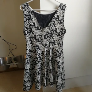  - Blommig klänning med dragkedja i ryggen. Stretchig. 