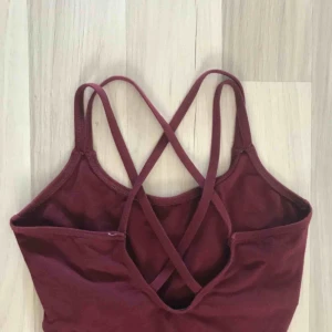  - En supersöt vinröd body med fin snörning i ryggen. Jättebra skick. Står S men skulle säga att den passar XS. Frakt tillkommer.