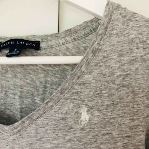  - Grå t-shirt med V-ringning från Ralph Lauren. I bra skick. Frakt ingår