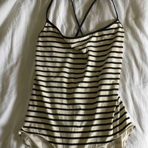  - Baddräkt från COS med djup rygg och korsade band som går att knäppa om. Använd endast en gång. Köpare står för frakt.