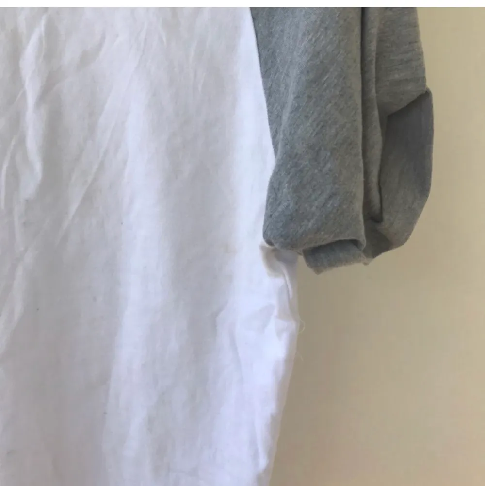 Så snygg vit T-shirt med gråa ärmar från ASOS. Aldrig använd men finns en liten fläck på höger sida (se bild) som måste ha blivit när jag flyttade. Går säkert bort i tvätt. Hur skön som helst i materialet och sitter supersnyggt! . T-shirts.