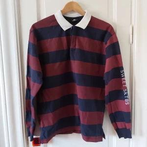 Rugbytröja sweet sktbs - Superskön randig rugbytröja/polo från sweet sktbs. Broderat på ärmen sweet sktbs. Fina röda o blåa ränder med en vit krage. Används för lite så säljer den. Är en herr M och sitter snyggt oversized på mig som har S dam. Schysst att croppa om man vill det.