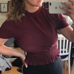 Topp/Blus - Frakt ingår i pris! Supersnygg vinröd topp med resor i midjan och knapp i nacken. Använd fåtal gånger. 