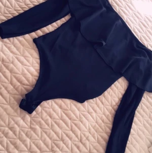 Body från Nelly  - En söt body från Nelly med volanger. 