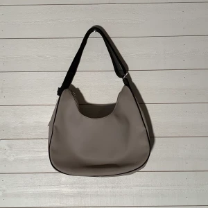 Lacoste Väska - Bredd: 32 cm  Längd: 27 cm  Färg: Beige/silver detaljer Märke: LACOSTE Fler bilder? Kontakta oss!