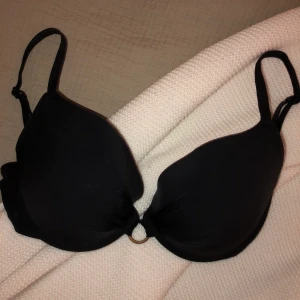 Svart bikiniöverdel  - En svart bikiniöverdel från HM med justerbara axelband och ett spänne i ryggen. Storlek 80B. Köparen står för frakten.