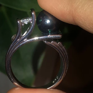 silver ring med svart pärla - jättefin silverring med små glittrande stenar samt en svart pärla. säljer pga för stor för mig. aldrig använd, inga repor osv. 