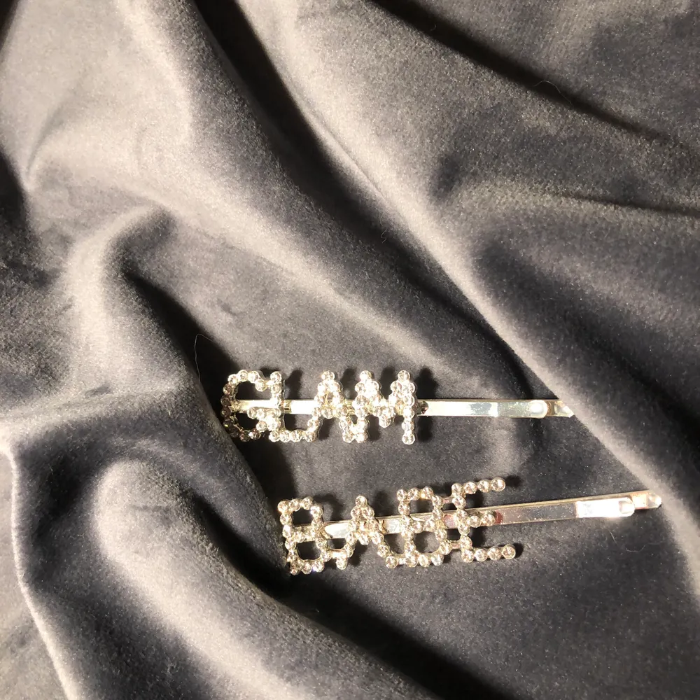 Två hårspännen där det står ”GLAM” och ”BABE”, används endast 1 gång. Säljs tillsammans. (Rengör såklart smycket innan jag skickar) . Accessoarer.