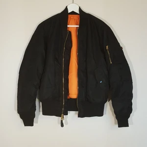 Alpha Industries MA-1 Bomberjacka - Vinterfodrad original Bomberjacka från amerikanska Alpha Industries. Klassisk oversize passform. Två ytterfickor, en ficka på ärmen, två innerfickor. Resår i midja, hals och ärmslut. I fint skick utan skador eller fläckar.