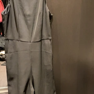 Jumpsuit med öppen rygg  - Svart jumpsuit med raka ben och öppen rygg. Använd ett fåtal gånger. 