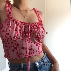 Croptop med hjärtan - En croptop med mönster av gulliga små hjärtan, helt ny och oanvänd. Toppen är från shein, materialet är stretchigt och ganska luftigt :)