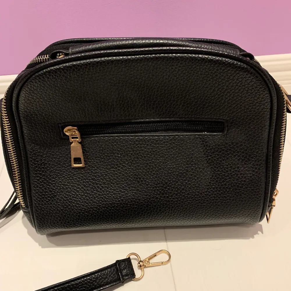 En fin svart väska med små gulddetlajer. Väskan har många dragkedjor samt kan användas på olika sätt. Bra skick och aldrig använd, inkl frakt men inte för dyrt!❤️✨. Väskor.
